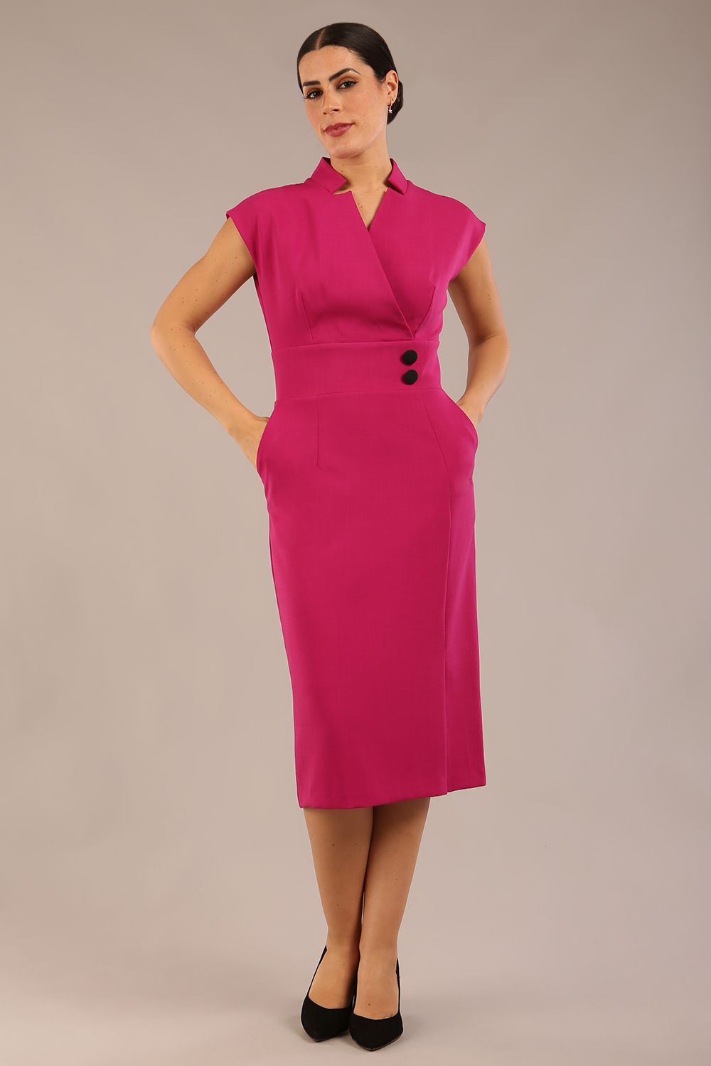 brunette Model is wearing a diva catwalk Derby pencil skirt dress cap sleeves with buttons details at the waistband and star neckline below the knee length with pockets in magenta colour front image (Magenta)