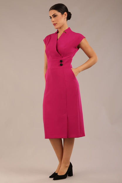brunette Model is wearing a diva catwalk Derby pencil skirt dress cap sleeves with buttons details at the waistband and star neckline below the knee length with pockets in magenta colour front image (Magenta)