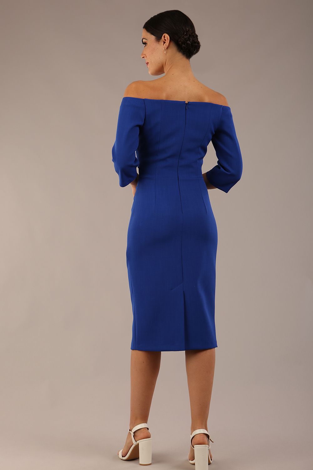 brunette model is wearing a diva catwalk lauren off shoulder asymmetric neckline pencil dress with sleeves in cobalt blue front 