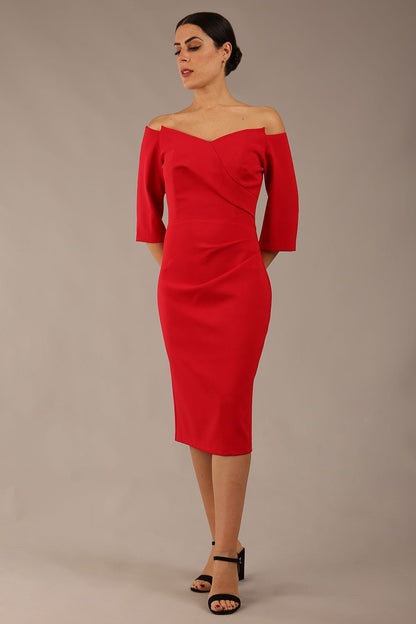 brunette model is wearing a diva catwalk lauren off shoulder asymmetric neckline pencil dress with sleeves in red front 