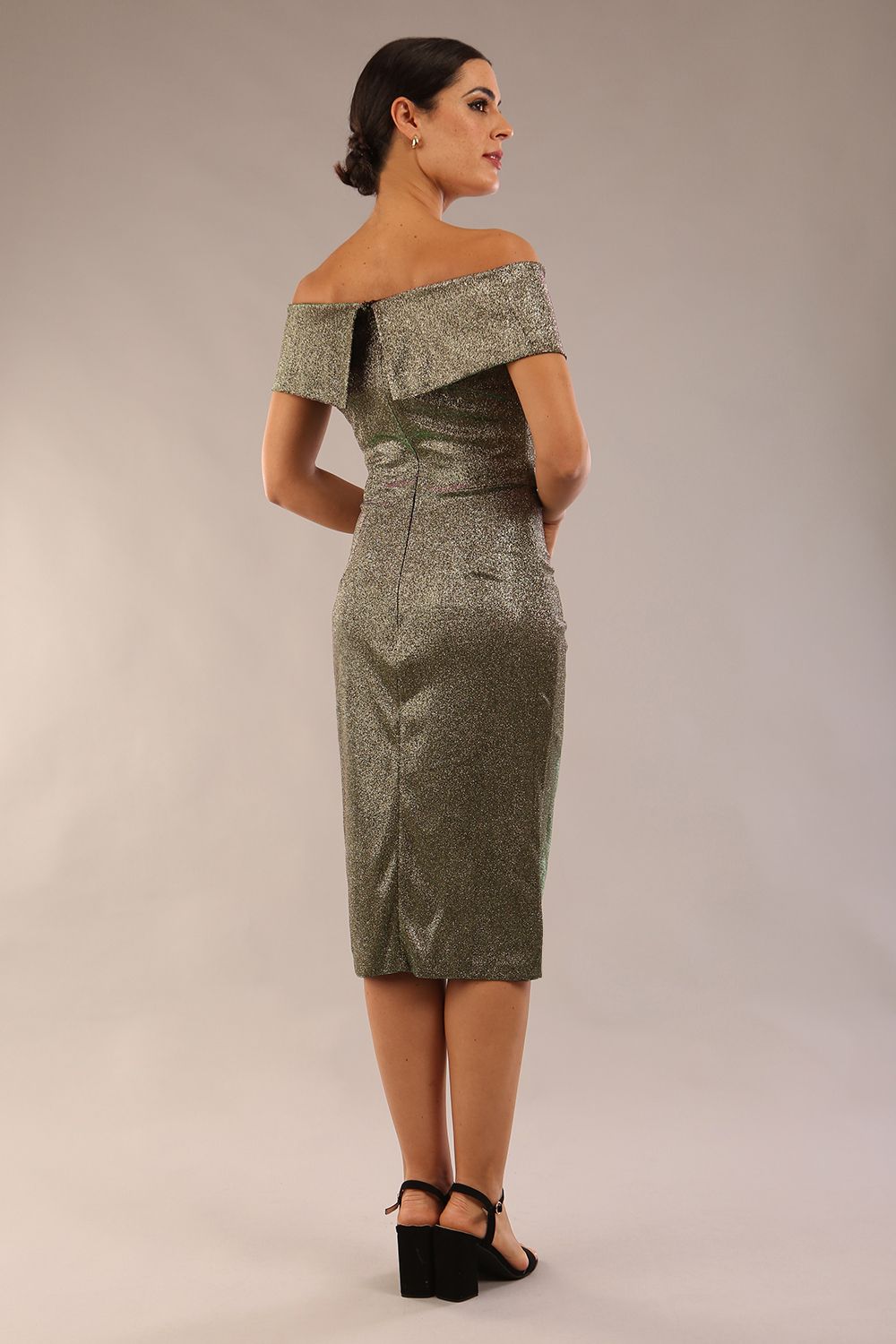 brunette model is wearing diva catwalk starlight tulip wrapped skirt woth off shoulder detail in sherwood gold glitter fabric front