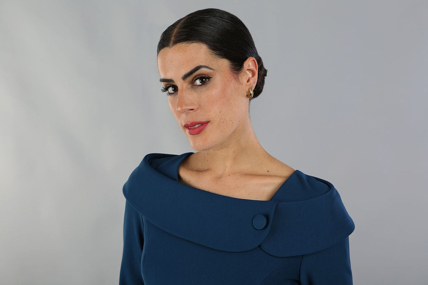 brunette model is wearing diva catwalk pencil dress with collar and a button detail on a side with 3/4 sleeve in glorious teal front close up