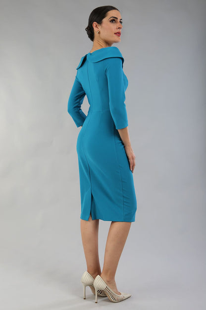 brunette model is wearing diva catwalk pencil dress with collar and a button detail on a side with 3/4 sleeve in mosaic blue back