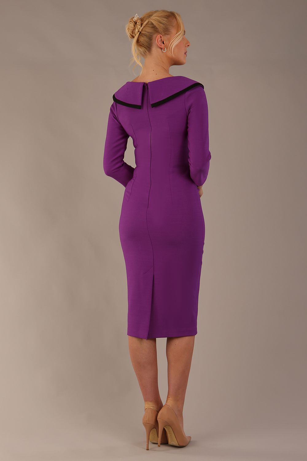 Model wearing diva catwalk Seed Elsye 3/4 Sleeve Knee Length Pencil Dress with Fold over bateau collar neckline with contrast piping and Bow feature on the left side of the bodice in Amethyst Purple colour front side (Amethyst Purple / Black Contrast)