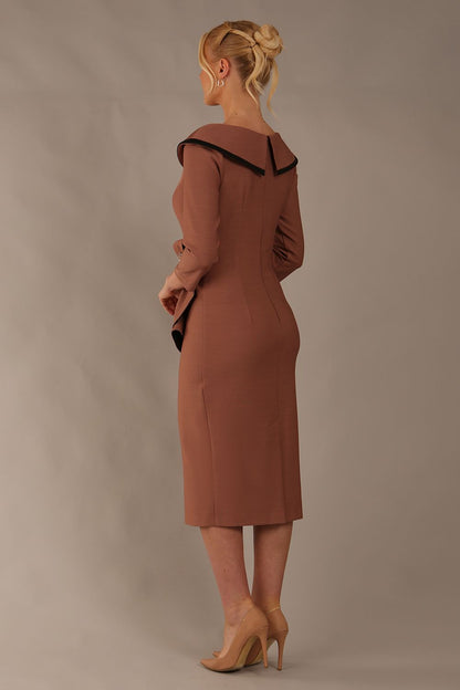 Model wearing diva catwalk Seed  Elsye 3/4 Sleeve Knee Length Pencil Dress with Fold over bateau collar neckline with contrast piping and Bow feature on the left side of the bodice with decorative brooch in Acorn Brown colour front (Acorn Brown / Black Contrast)