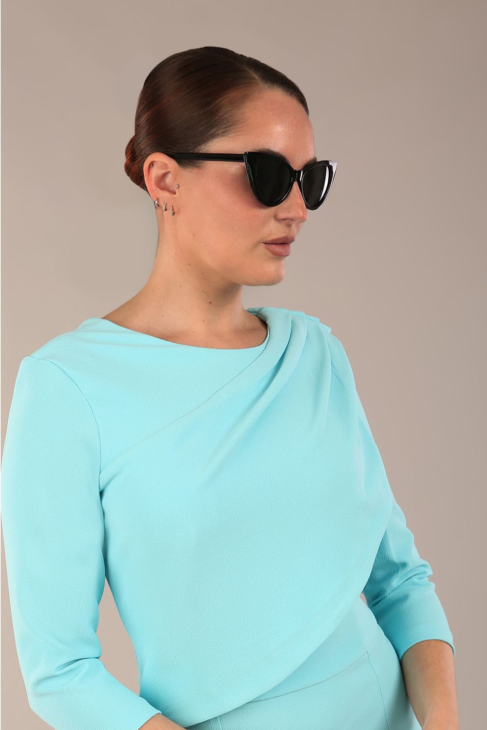 brunette model is wearing a diva catwalk Frieth Gathered Shoulder Dress 3/4 sleeves knee length with shoulder detail in turquoise colour front image with a hat
