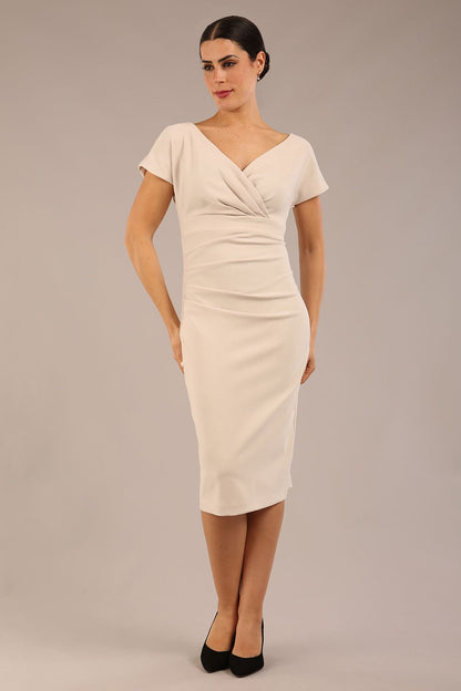 Model is wearing Brooke Cap Sleeve Pencil Dress in Couture Stretch Fabric with V Neckline and Hip Pleating in Sandy Cream front