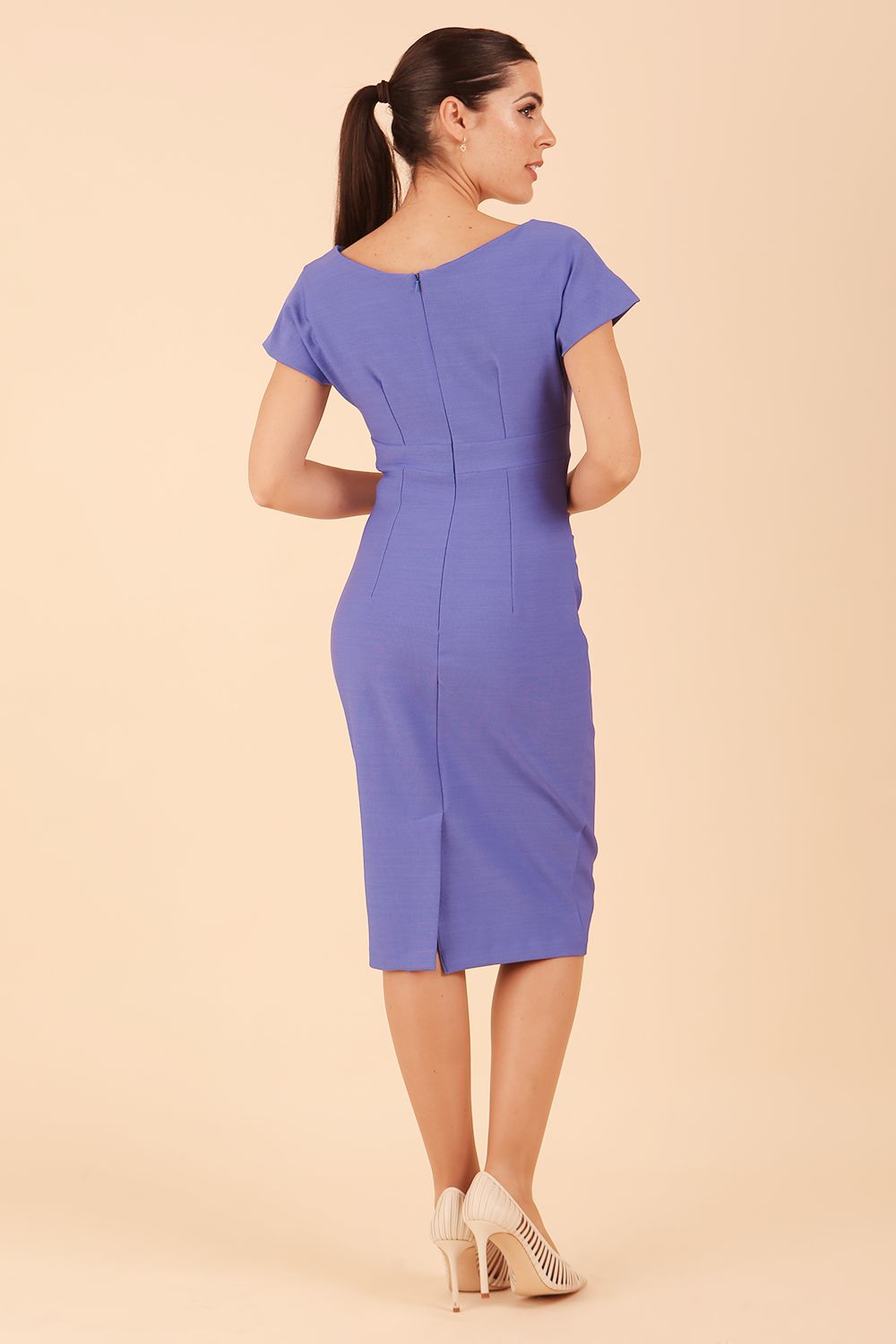 Model is wearing Brooke Cap Sleeve Pencil Dress in Couture Stretch Fabric with V Neckline and Hip Pleating in Thistle Blue back side