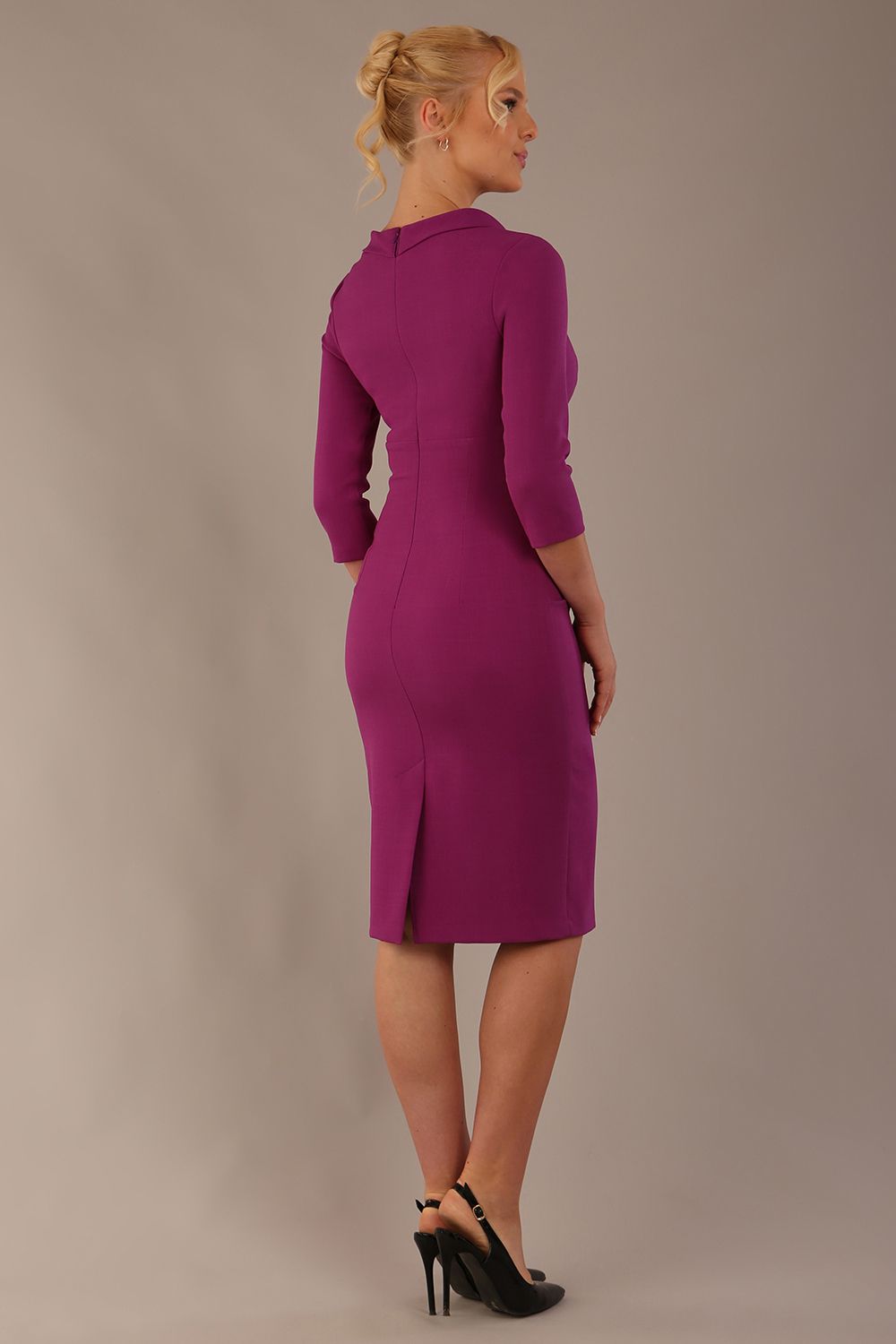 The model is wearing a diva catwalk Juliette 3/4 Sleeve Knee Length dress with bow detail in hollyhock purple colour against a plain background