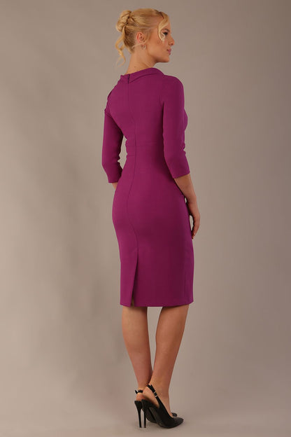 The model is wearing a diva catwalk Juliette 3/4 Sleeve Knee Length dress with bow detail in hollyhock purple colour against a plain background
