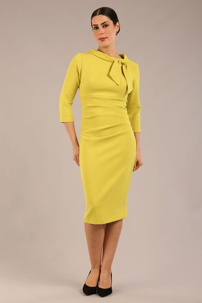 Model is wearing a diva catwalk Juliette 3/4 Sleeve Knee Length dress with bow detail in citrus green colour
