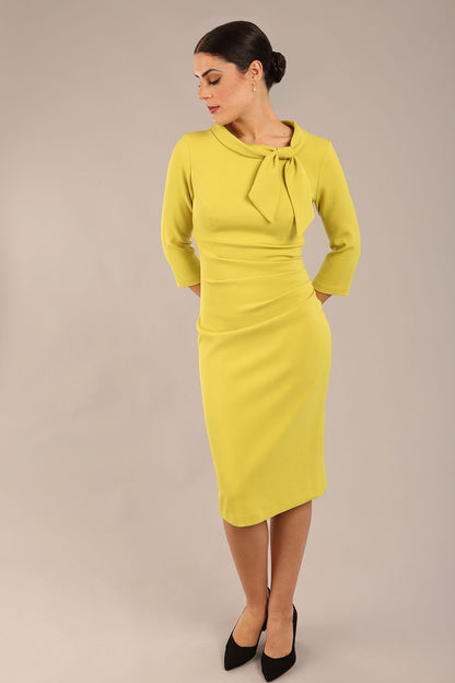 Model is wearing a diva catwalk Juliette 3/4 Sleeve Knee Length dress with bow detail in citrus green colour