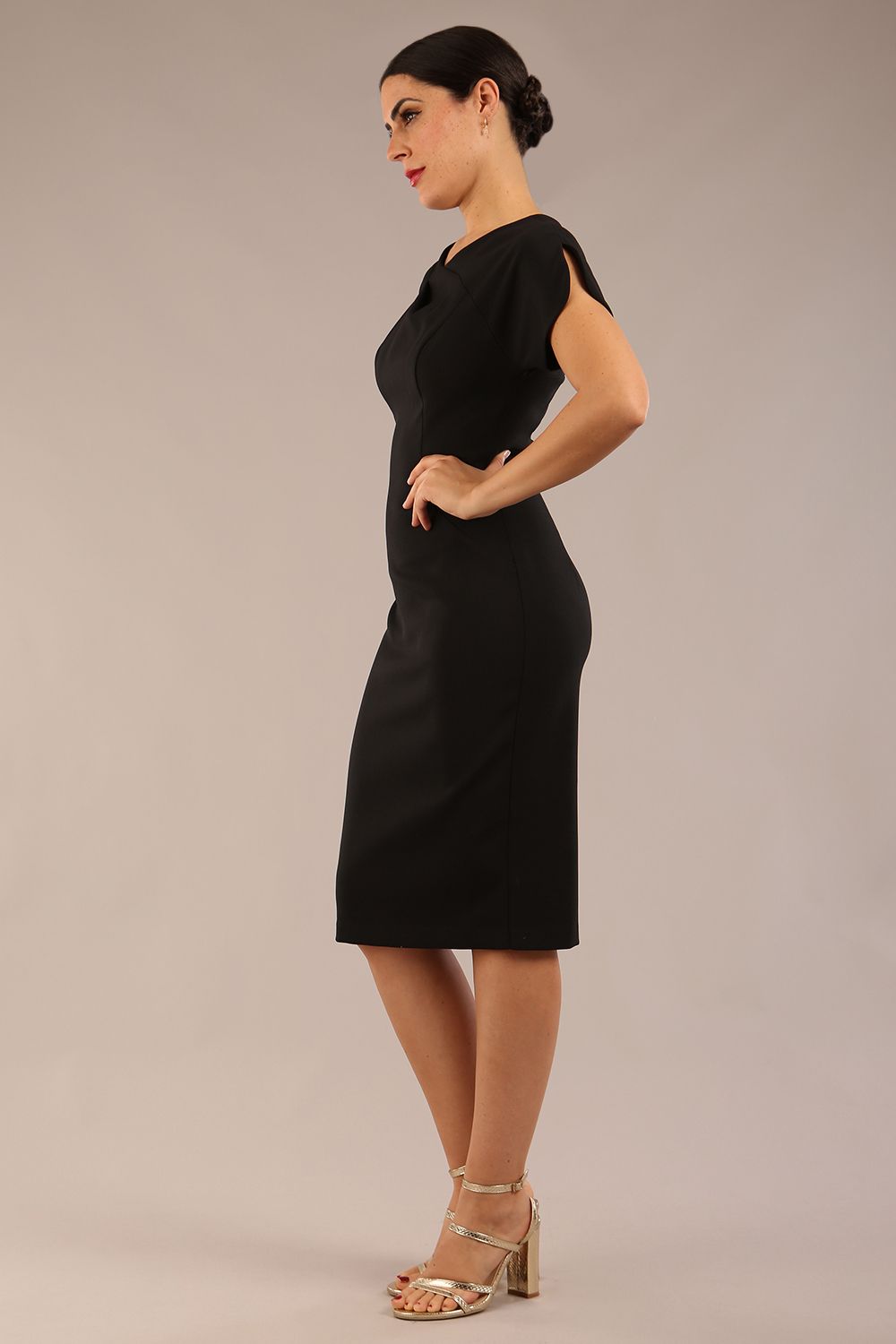 brunette Model wearing a diva catwalk Sheena Short Sleeve with an open split Knee Length Pencil Dress with Diamond Neckline in Black colour back