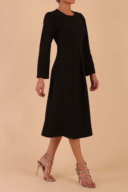 Model wearing diva catwalk in Bombay fabric the Epsom Long Sleeve and round neckline and midi A-Line Dress in Black colour front side (Black)