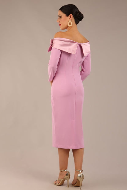 brunette Model is wearing a diva catwalk Rosalind Off Shoulder Bow Detail Pencil Dress 3/4 sleeve in Dawn Pink contrast front image (Dawn Pink)