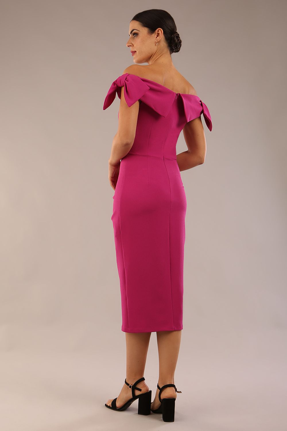 model is wearing a diva catwalk Strand Off-Shoulder Bow Tie Dress midi length and pleated skirt in magenta haze colour