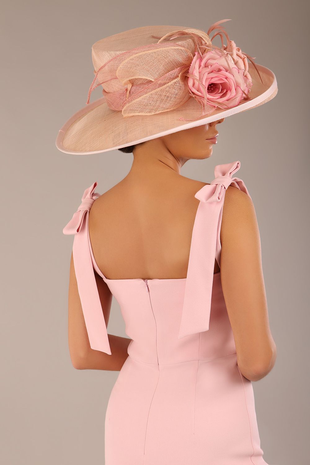 brunette model wearing a diva catwalk Philippa Pencil Wiggle Dress sleeveless style, tie detail on the shoulders knee length and sweetheart neckline in crystal pink colour front 