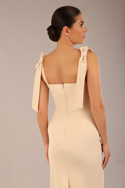 brunette model wearing a diva catwalk Philippa Pencil Wiggle Dress sleeveless style, tie detail on the shoulders knee length and sweetheart neckline in sandshell beige  front