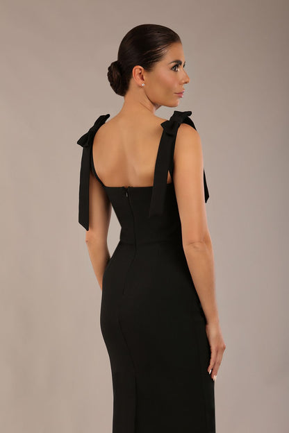 brunette model wearing a diva catwalk Philippa Pencil Wiggle Dress sleeveless style, tie detail on the shoulders knee length and sweetheart neckline in black colour front 