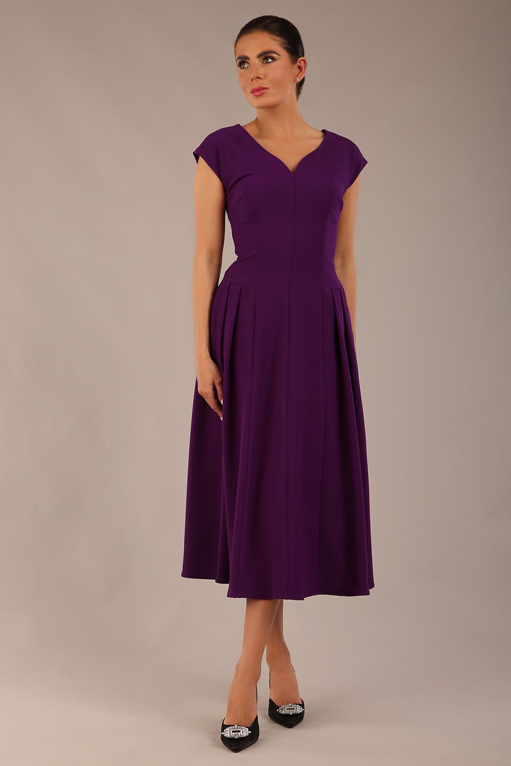 brunette model is wearing a diva catwalk Audrey a-line Dress sweetheart neckline and With Pockets and sleeveless with ankle length in passion purple colour back