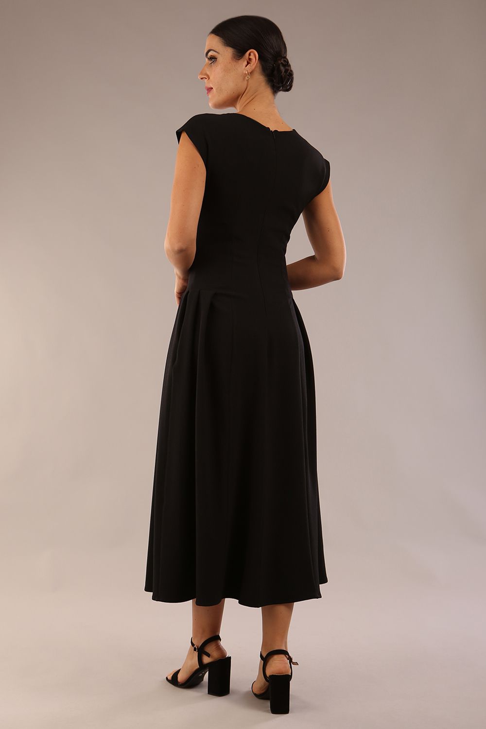 brunette model is wearing a diva catwalk Audrey a-line Dress sweetheart neckline and With Pockets and sleeveless with ankle length black colour back