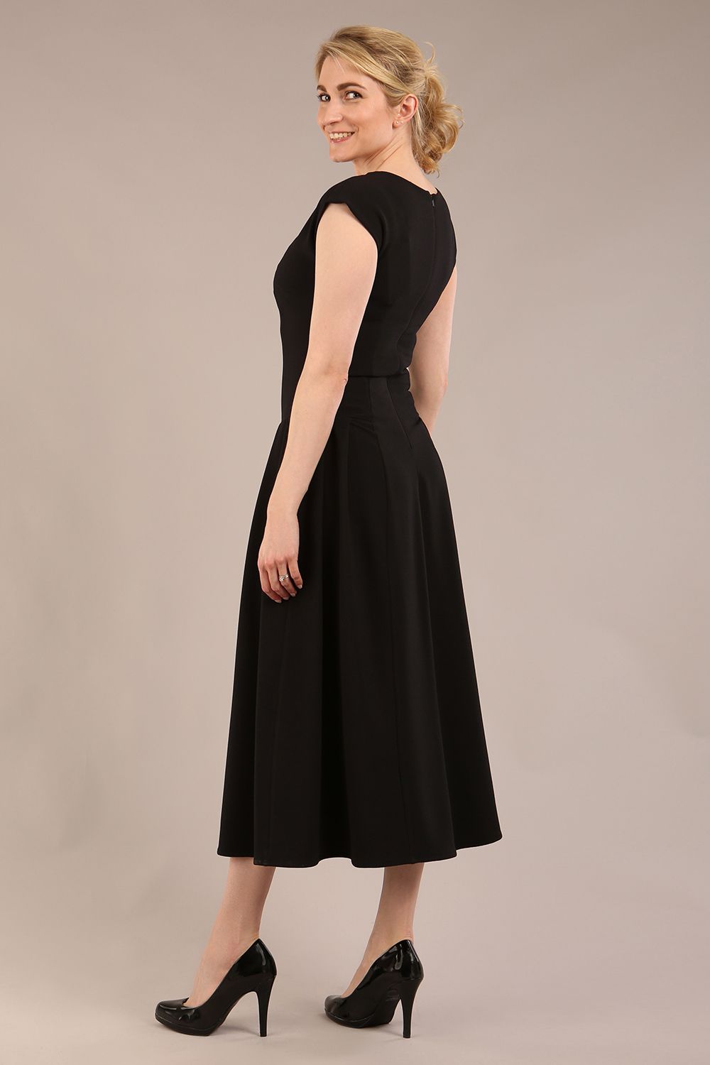 brunette model is wearing a diva catwalk Audrey a-line Dress sweetheart neckline and With Pockets and sleeveless with ankle length black colour back
