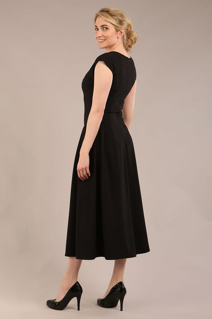 brunette model is wearing a diva catwalk Audrey a-line Dress sweetheart neckline and With Pockets and sleeveless with ankle length black colour back