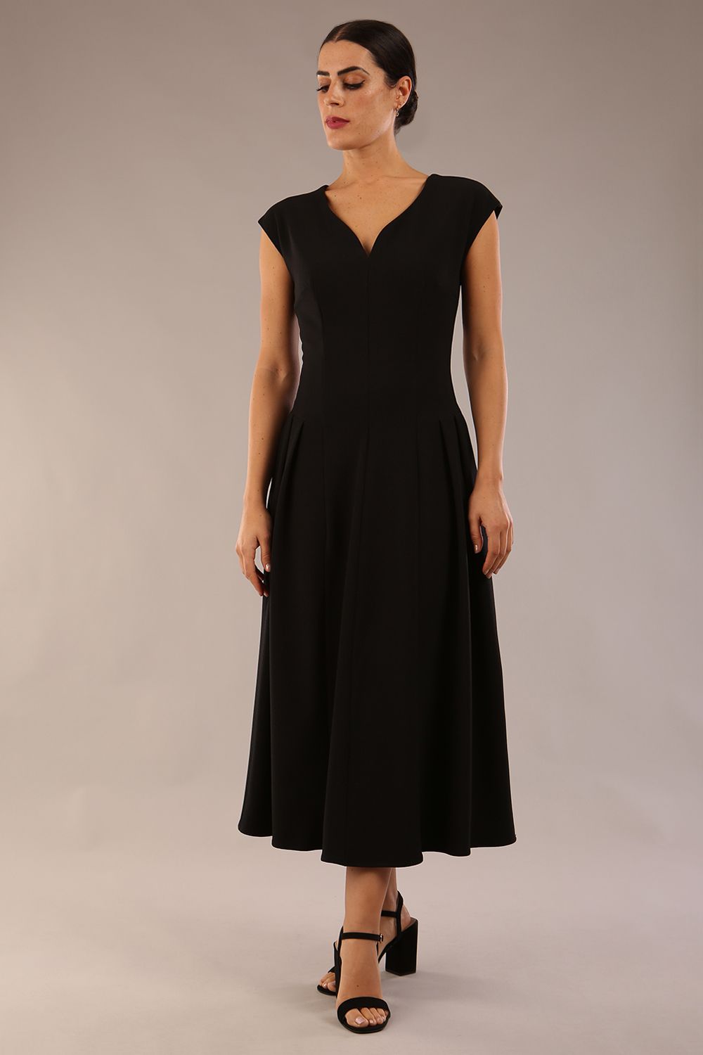 brunette model is wearing a diva catwalk Audrey a-line Dress sweetheart neckline and With Pockets and sleeveless with ankle length black colour back