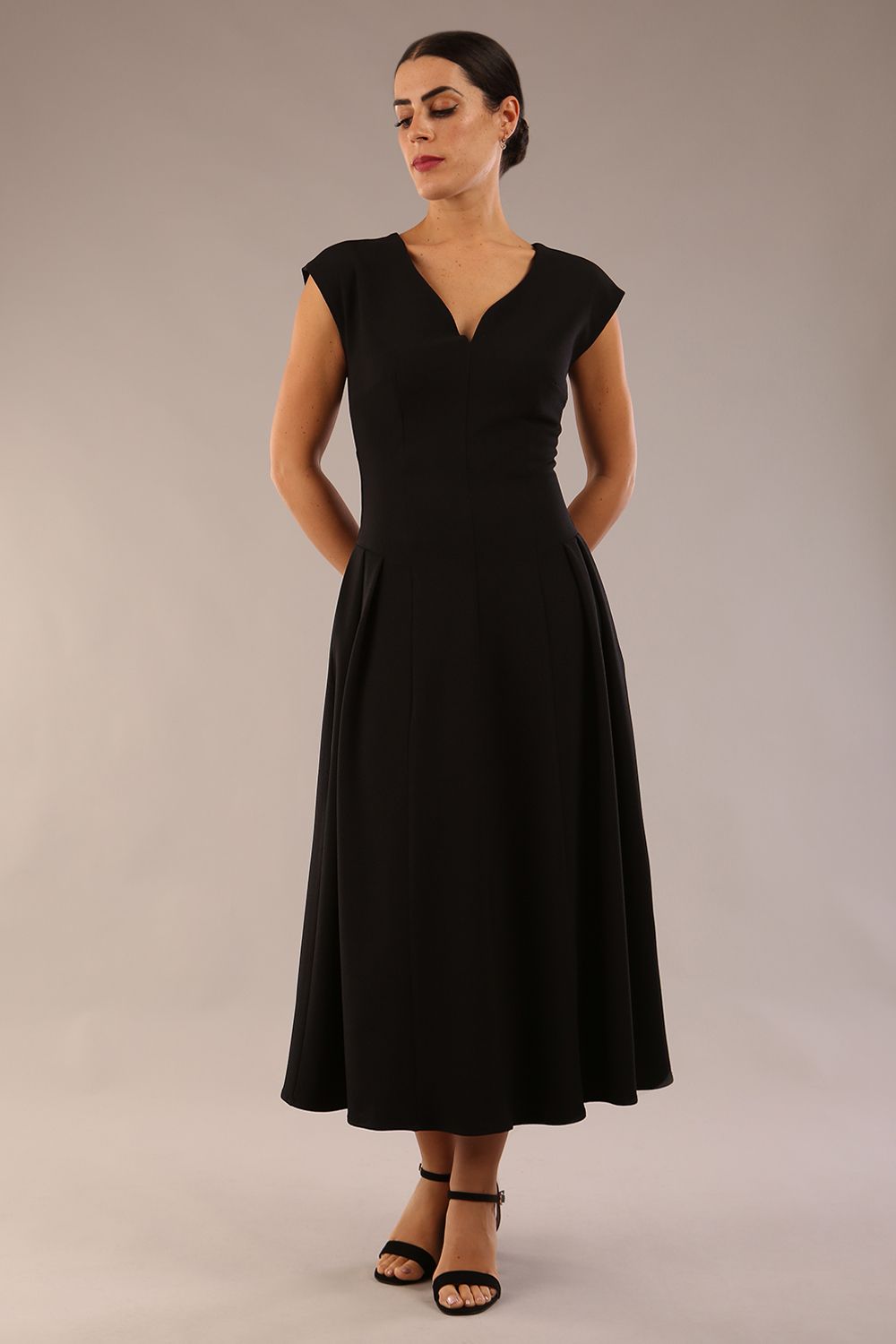 brunette model is wearing a diva catwalk Audrey a-line Dress sweetheart neckline and With Pockets and sleeveless with ankle length black colour back