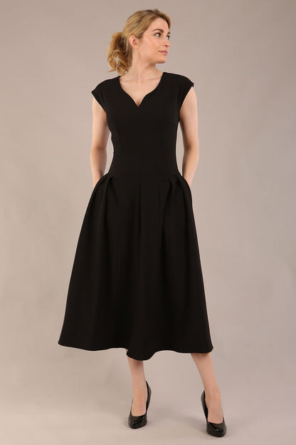 brunette model is wearing a diva catwalk Audrey a-line Dress sweetheart neckline and With Pockets and sleeveless with ankle length black colour back