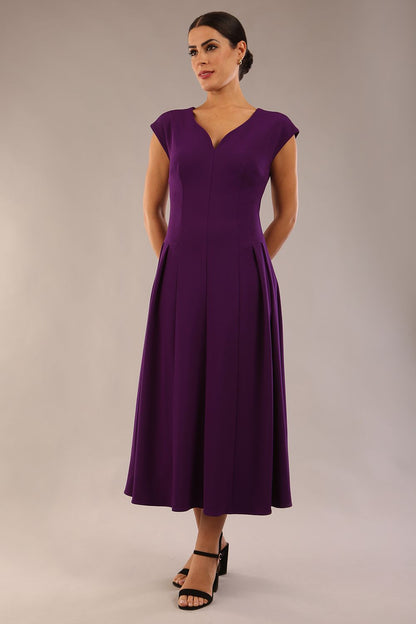 brunette model is wearing a diva catwalk Audrey a-line Dress sweetheart neckline and With Pockets and sleeveless with ankle length in passion purple colour back