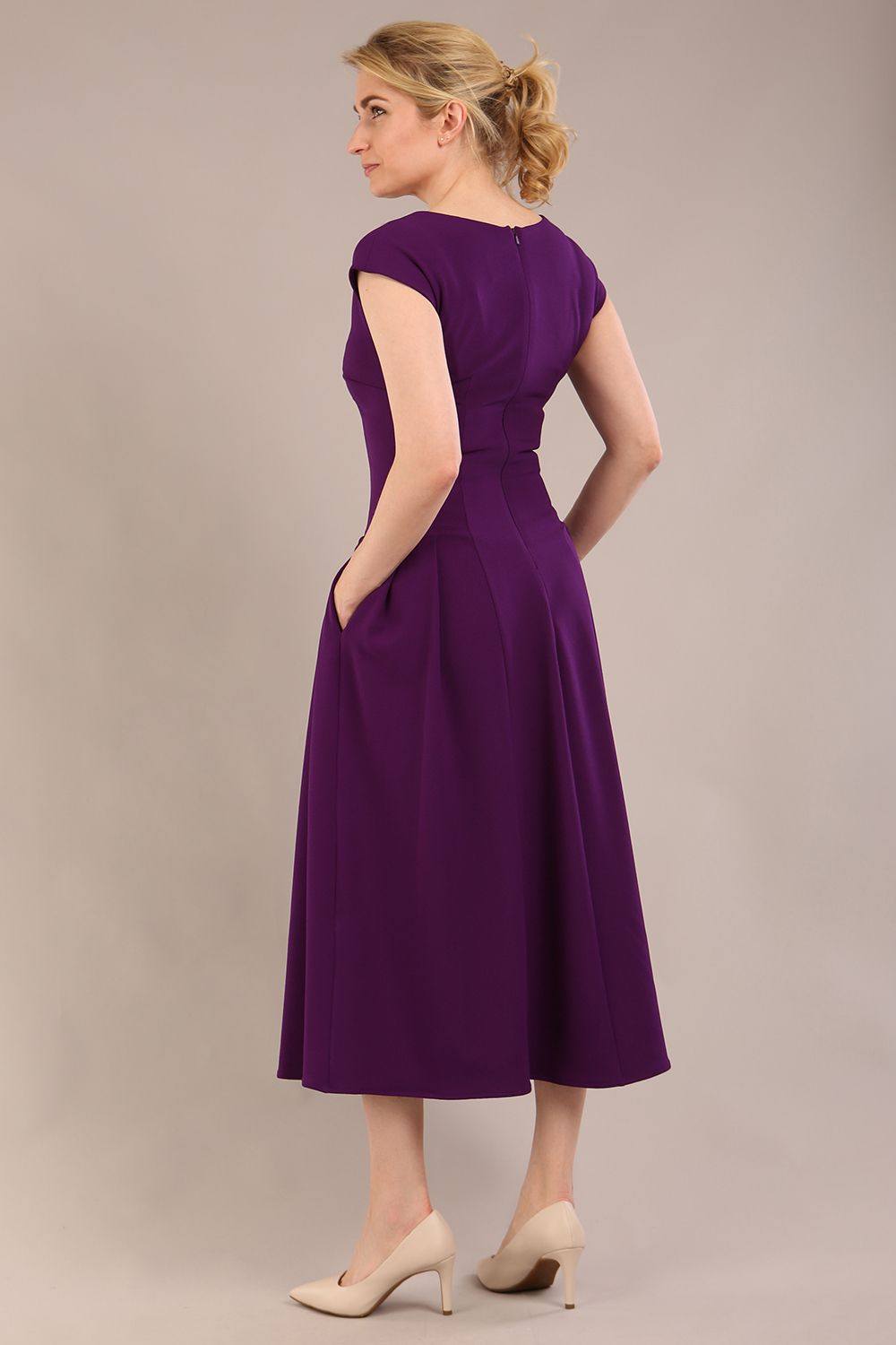 brunette model is wearing a diva catwalk Audrey a-line Dress sweetheart neckline and With Pockets and sleeveless with ankle length in passion purple colour back