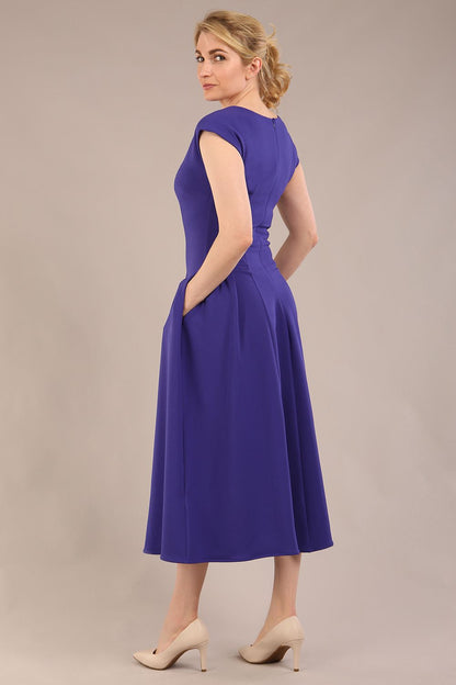 brunette model is wearing a diva catwalk Audrey a-line Dress sweetheart neckline and With Pockets and sleeveless with ankle length in spectrum indigo colour back