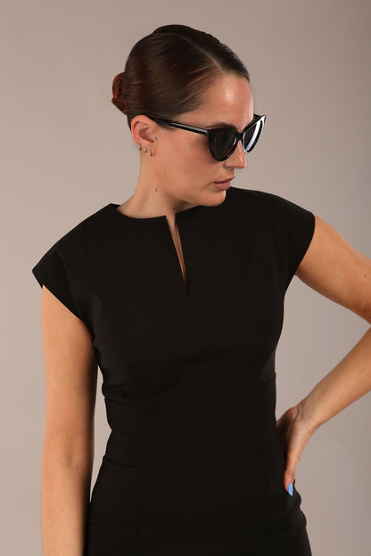 brunette model is wearing a diva catwalk Claire Cap Sleeve Pencil Dress cap sleeve with round neckline with v-slit and knee length in black colour front (Black)