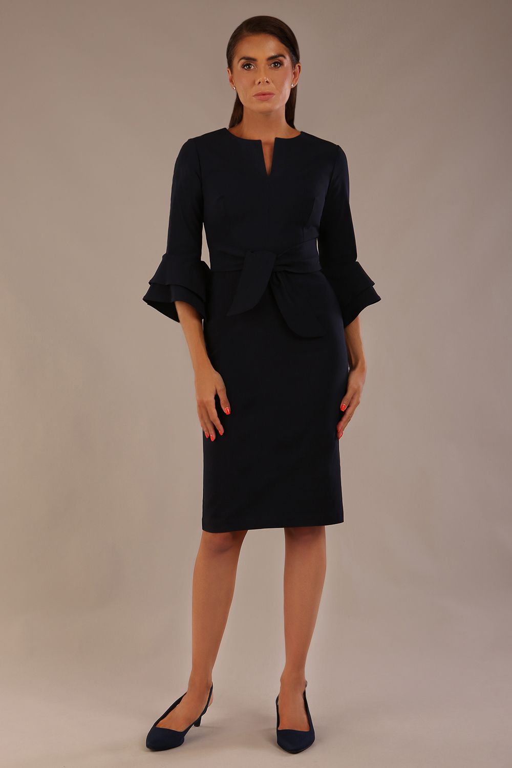 brunette model is wearing a diva catwalk Hobson ruffled sleeves Pencil Dress with tie waistband knee length in Dark Navy colour front (Dark Navy)
