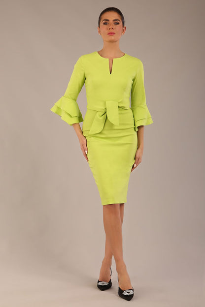 A model wearing a pink knee-length pencil dress with ruffled sleeves and a waist belt, standing against a plain background (Lime Green)