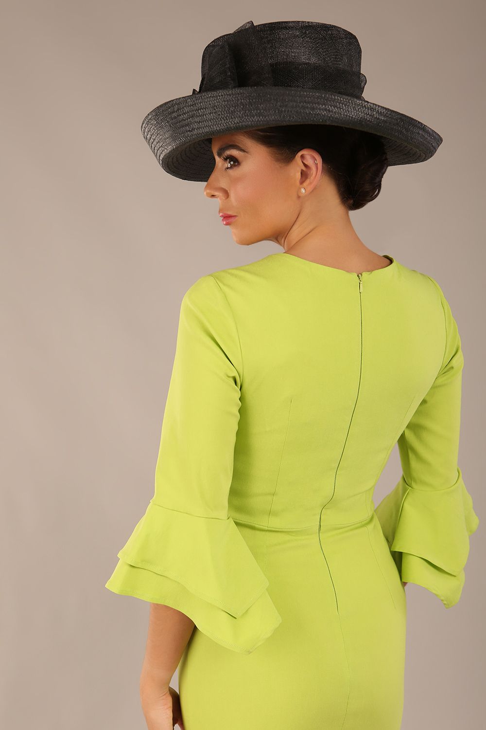 A model wearing a pink knee-length pencil dress with ruffled sleeves and a waist belt, standing against a plain background (Lime Green)
