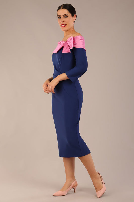 Model is wearing a Rosalind Off Shoulder Bow Detail Pencil Dress 3/4 sleeve in Navy Blue/ Pink contrast front image (Navy Blue / Pink Pearl Contrast)