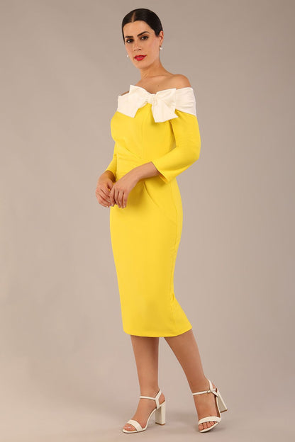 brunette Model is wearing a Rosalind Off Shoulder Bow Detail Pencil Dress 3/4 sleeve in Blazing Yellow / Ivory cream contrast front image (Blazing Yellow / Ivory)