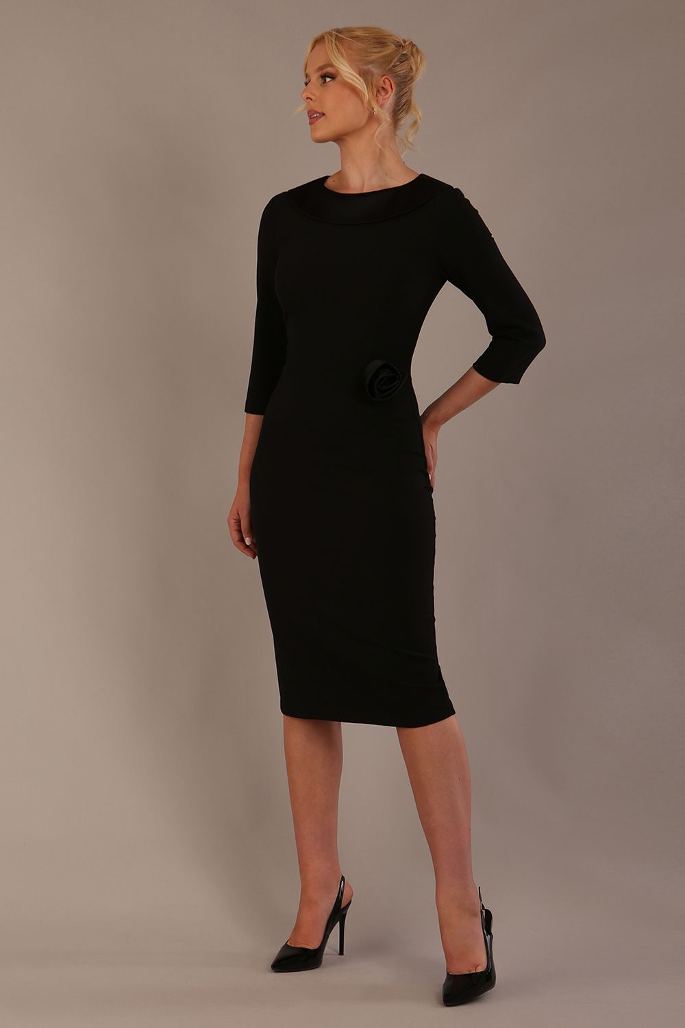 Woman wearing a Heathcote Floral Detail Pencil Dress with a plain background in black close up