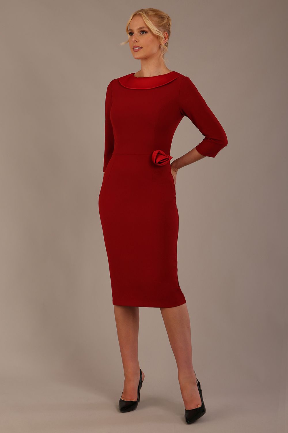 Woman wearing a Heathcote Floral Detail Pencil Dress with a plain background in rosewood red close up view