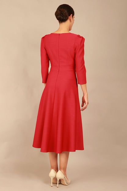 A model wearing a red, 3/4 sleeve A-line dress with pockets, featuring a boat neckline and vent at the centre back (Crimson Pink)