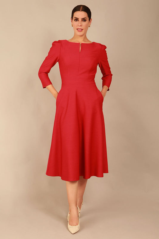 A model wearing a red, 3/4 sleeve A-line dress with pockets, featuring a boat neckline and vent at the centre back (Crimson Pink)