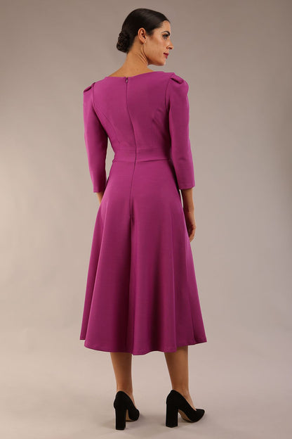 A model wearing a red, 3/4 sleeve A-line dress with pockets, featuring a boat neckline and vent at the centre back (Dawn Purple)