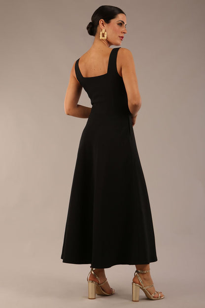 brunette model wearing a diva catwalk Tamsin Square Neckline Swing Dress sleeveless style with a midaxi  length and side pockets in Black colour front (Black)