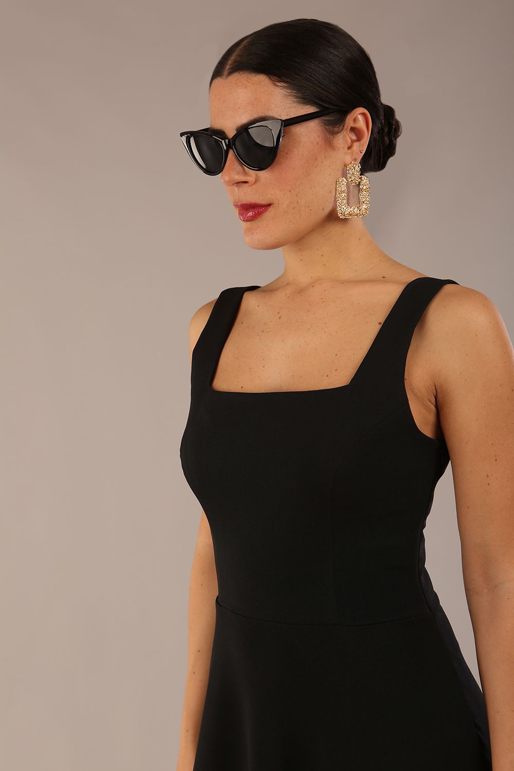 brunette model wearing a diva catwalk Tamsin Square Neckline Swing Dress sleeveless style with a midaxi  length and side pockets in Black colour front (Black)