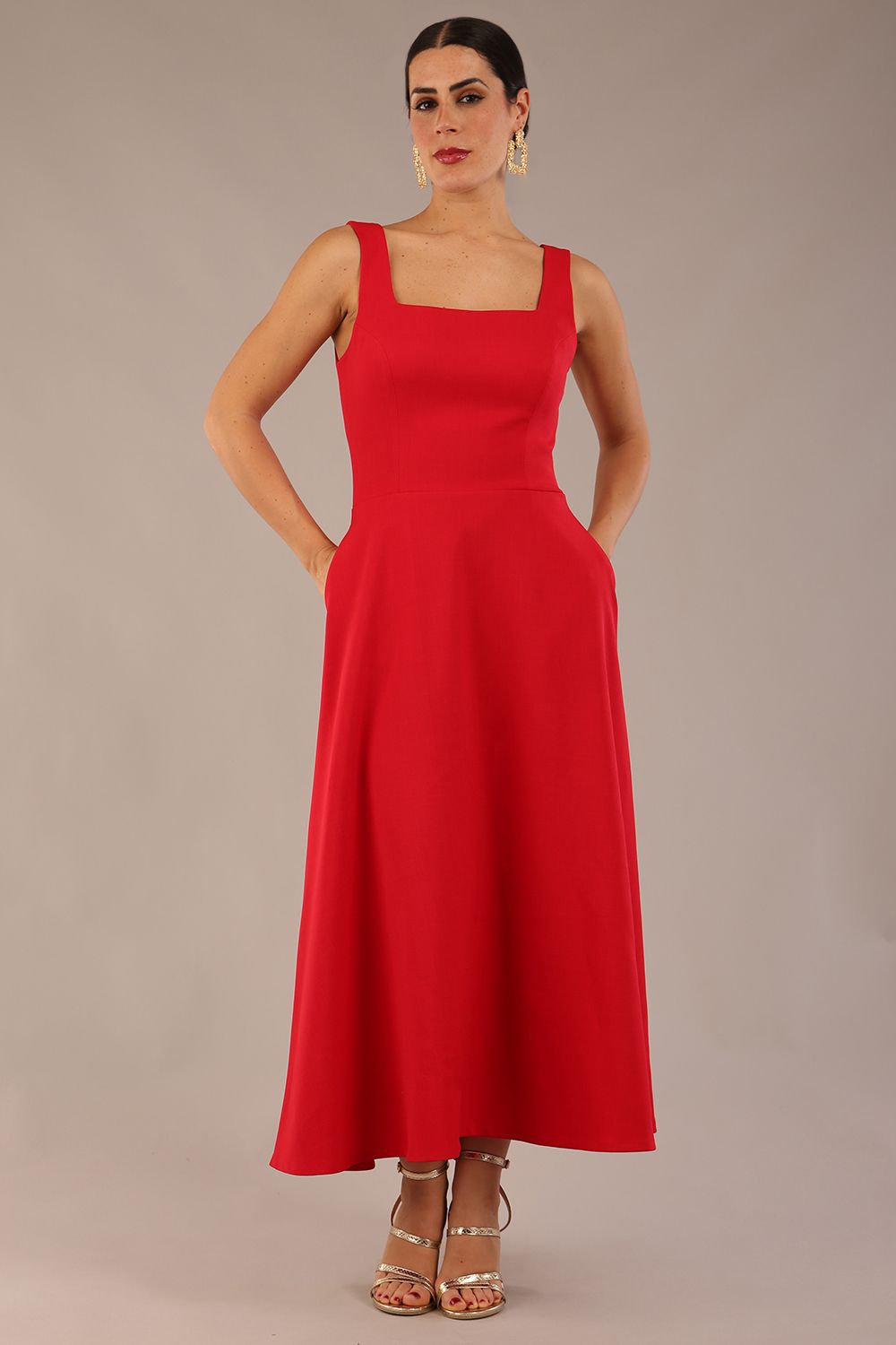 woman wearing a diva catwalk Tamsin Square Neckline Swing Dress sleeveless style with a midaxi  length and side pockets in Scarlet Red colour in Budapest (Scarlet Red)