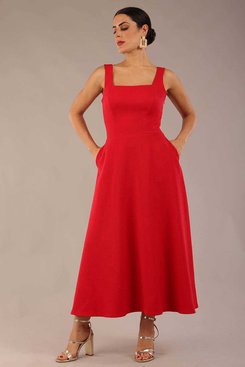 woman wearing a diva catwalk Tamsin Square Neckline Swing Dress sleeveless style with a midaxi  length and side pockets in Scarlet Red colour in Budapest (Scarlet Red)