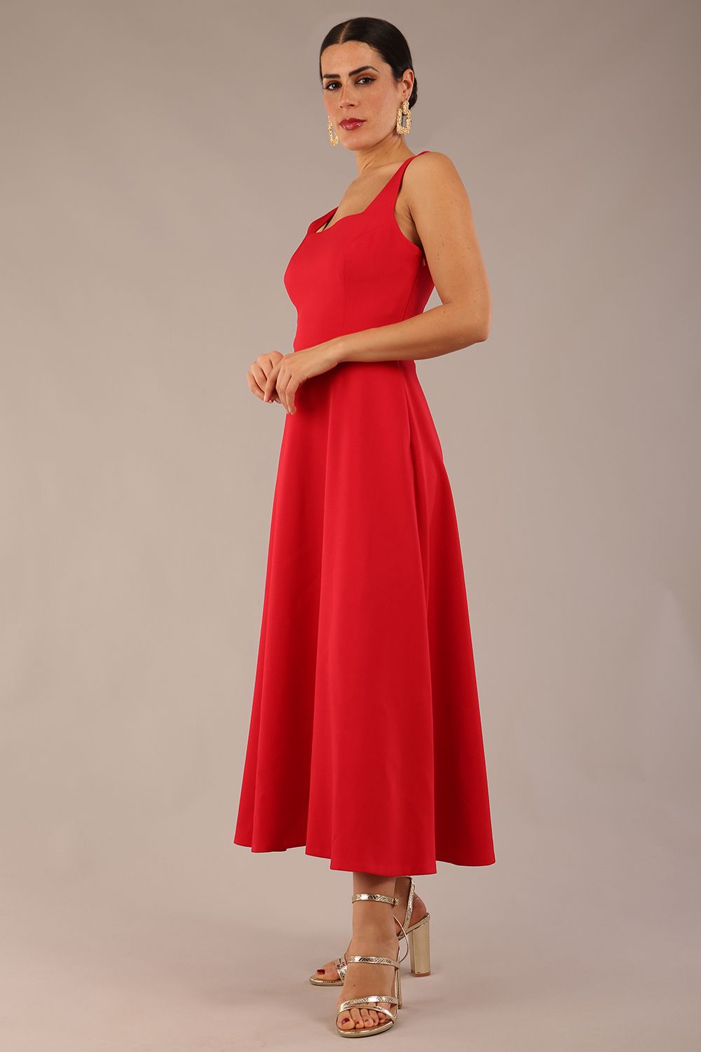 woman wearing a diva catwalk Tamsin Square Neckline Swing Dress sleeveless style with a midaxi  length and side pockets in Scarlet Red colour in Budapest (Scarlet Red)