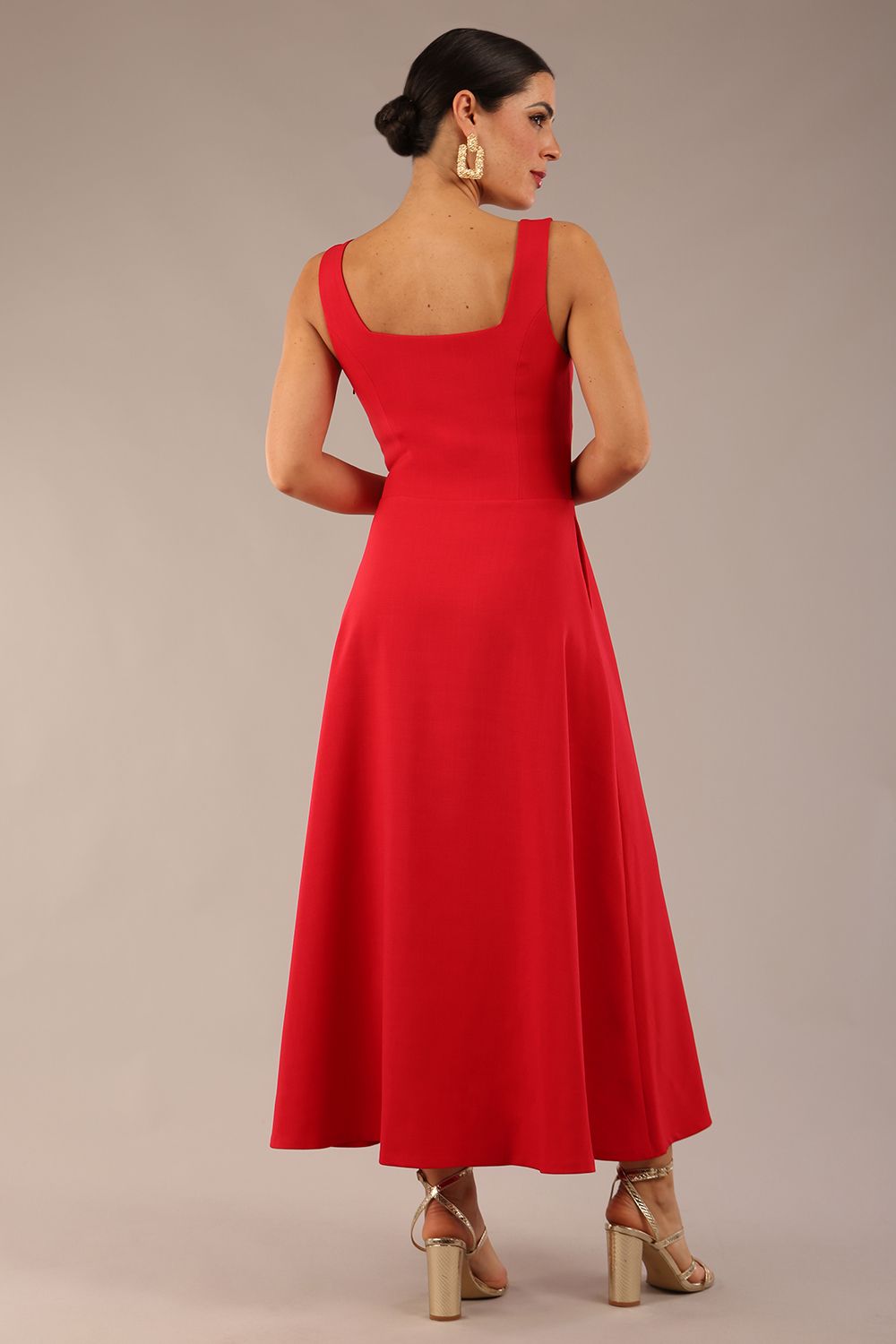woman wearing a diva catwalk Tamsin Square Neckline Swing Dress sleeveless style with a midaxi  length and side pockets in Scarlet Red colour in Budapest (Scarlet Red)